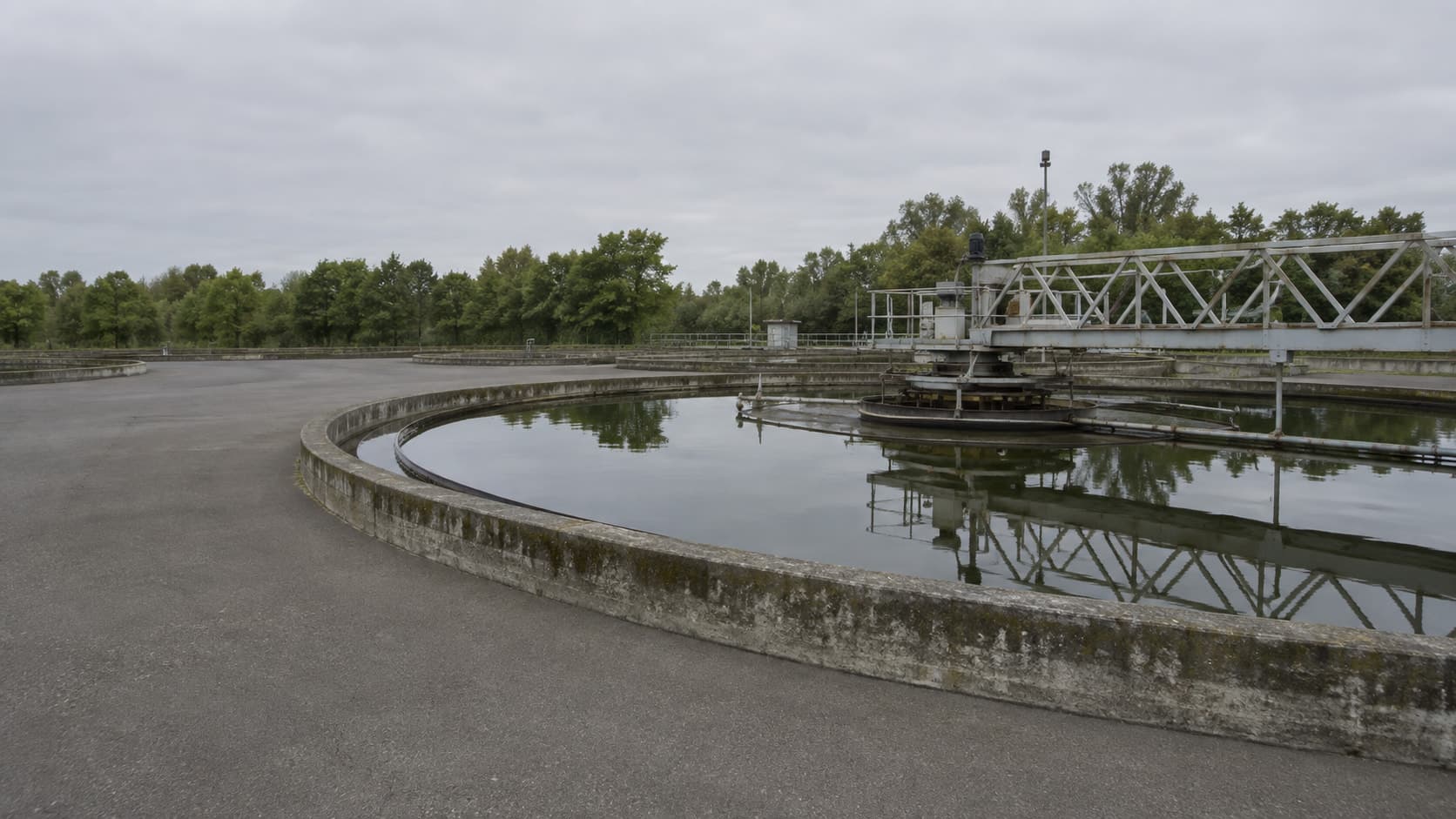 Sedimentador circular de una planta de tratamiento, con el puente barredor sobre el agua.